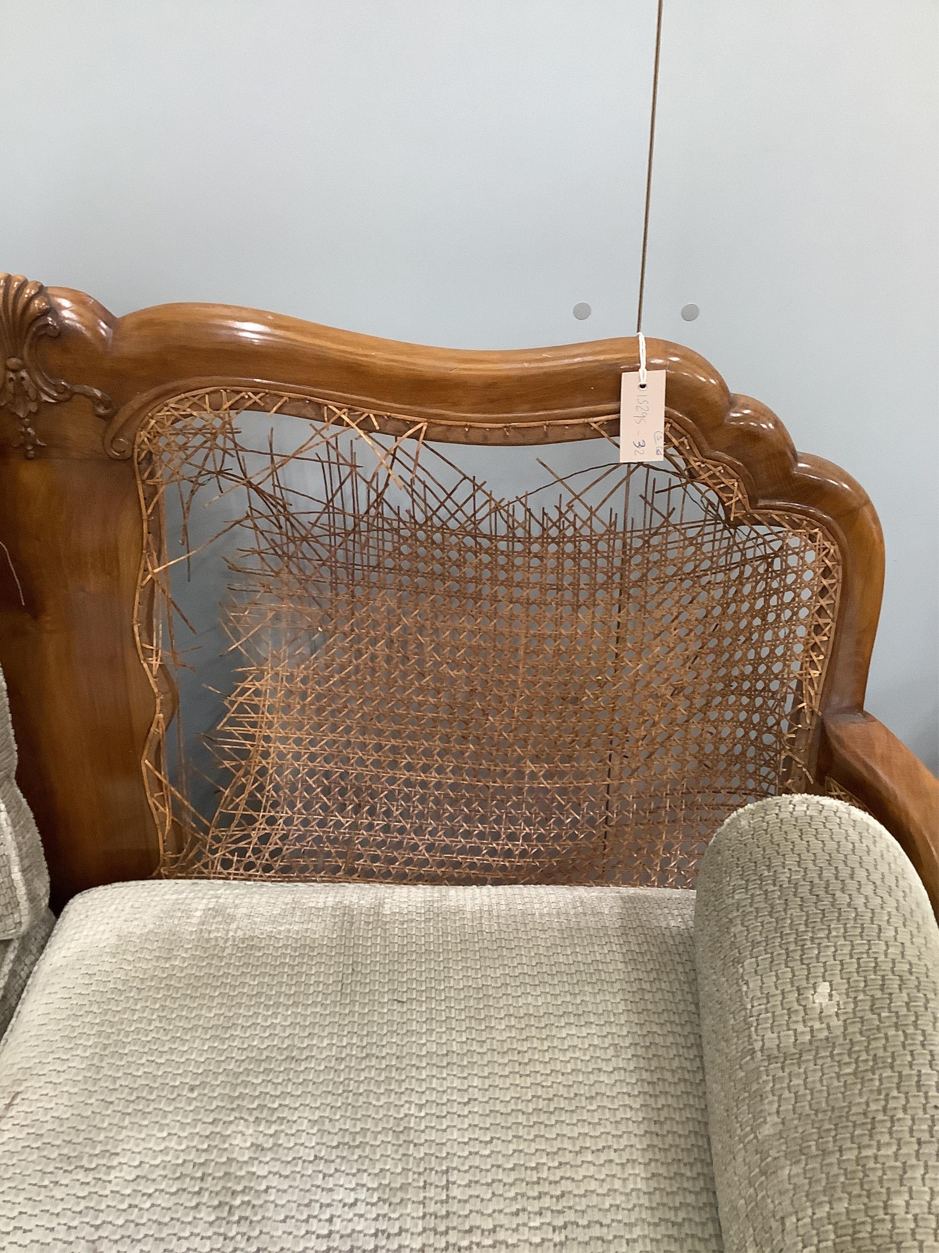A Queen Anne Revival walnut three piece Bergere suite, cane in need of extensive repair, settee width 156cm, depth 74cm, height 94cm. Condition - poor
